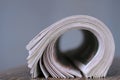newspaper rolled up and sitting on a table no people stock photo Royalty Free Stock Photo