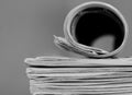 newspaper rolled up and sitting on a table no people stock photo Royalty Free Stock Photo