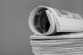 newspaper rolled up and sitting on a table no people stock photo Royalty Free Stock Photo