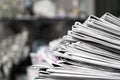 Newspapers folded and stacked on the table dark background. Image shallow depth of field