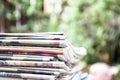 Newspapers folded and stacked on the table with garden or green background. Closeup newspaper and selective focus image. Time to r