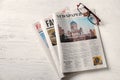 Newspapers and glasses on white wooden background Royalty Free Stock Photo