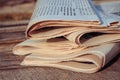 Newspapers on old wood background. Toned image. Royalty Free Stock Photo