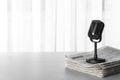 Newspapers and vintage microphone on grey table, space for text Royalty Free Stock Photo