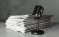 Newspapers and vintage microphone on grey stone table. Journalist`s work Royalty Free Stock Photo