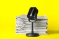 Newspapers and vintage microphone on yellow background. Journalist`s work Royalty Free Stock Photo