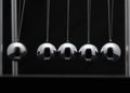 Closeup Of Newton Cradle With Swinging Metal Balls Royalty Free Stock Photo