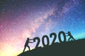 2020 Newyear Couple tries to push number of 2020 Happy new year background on the Milky Way galaxy