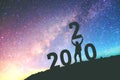 2020 Newyear Man tries to Lift up number of 2020 Happy new year background on the Milky Way galaxy