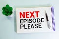 Next Episode Please text on hand drawn web browser paper on desk. Binge-watching shows concept, selective focus