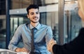 And so the next phase of the project begins. a young businessman and businesswoman shaking hands during a meeting in a Royalty Free Stock Photo