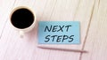 NEXT STEPS text on the blue sticker with cofee and pen Royalty Free Stock Photo