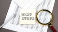 NEXT STEPS text on sticker on the chart ,with calculator and magnifier Royalty Free Stock Photo