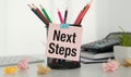 Next steps text on sticker, income tax time note. Office background. Business Concept. Royalty Free Stock Photo