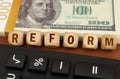 Next to the calculator and dollars are cubes with the inscription - REFORM Royalty Free Stock Photo