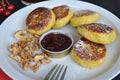 Next to the cheese pancakes are walnuts, jam and cherries Royalty Free Stock Photo