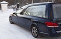 Next to the church stands a black funeral car