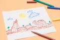 Next to the colored markers is a primitive children`s drawing with a felt-tip pen on a peach background. child development. Royalty Free Stock Photo