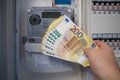 next to an electric meter is held a lot of two hundred euro banknotes Royalty Free Stock Photo