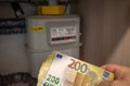 next to a gas meter is held a lot of two hundred euro banknotes Royalty Free Stock Photo