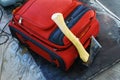 Next to the red suitcase lies an ax. Dangerous items in the luggage of tourists. Close-up Royalty Free Stock Photo