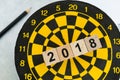 Next year planning target concept with wooden blocks number 2018 on dart board and pencil