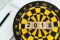 Next year planning target concept with wooden blocks number 2018 on dart board and pencil