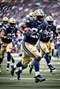 an NFL running back breaking through the defensive line and sprinting towards the end zone Royalty Free Stock Photo