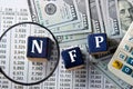 NFP - acronym on wooden cubes against the background of banknotes and calculator Royalty Free Stock Photo