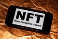 NFT non - fungible token black inscription on phone screen.