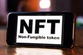 NFT non - fungible tokens black inscription on phone screen.