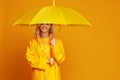 Ng happy emotional girl laughing with umbrella on colored yellow background