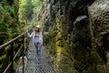 Girl in a working helmet is in the rocks near the waterfall