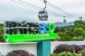 Ngong Ping 360 Skyrail on Lantau Island in Hong Kong is worlds most amazing cable car experience. Big sign on cable way line backg
