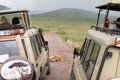 Crowd of safari vehicles gather around a pride of lions resting in the middle of the