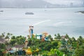 Nha Trang Bay with colorful water park, cruise, watercraft on the beach and row of downtown skylines high-rise apartment, mountain