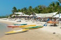 Colored kayaks and oars on a sandy beach and tropic parasols Royalty Free Stock Photo