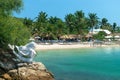 NHA TRANG, VIETNAM - APRIL 19, 2019: Sculpture of a mermaid on beach and thatched houses on the sand in the tropics