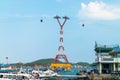 NHA TRANG, VIETNAM - APRIL 19, 2019: Tall funicular support at sea and boats in port with clear sky