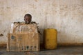 Portrait of a young boy playing in a card box in the town of Nhacra in Guinea Bissau