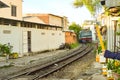 NIACHANG, VIETNAM - JANUARY 20, 2020: A blue train runs through the railway close to houses and retail outlets in the city of Nha