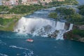 Niagara Falls over river with rocks and boat. Royalty Free Stock Photo