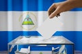 Nicaragua flag, hand dropping ballot card into a box - voting, election concept