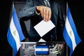 Nicaragua flags, hand dropping voting card - election concept