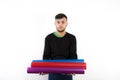 Nice and affable modern young worker with beard holding vinyl rolls