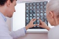 Nice aged woman pointing at the brain X ray image