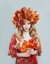 Nice autumn woman in fall leaves crown on gray background