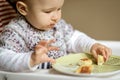 The nice baby with messy face eating cheese cakes