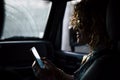 Nice beautiful middle age woman travel inside a car shile rain outside. using a smartphone to connect and call friends and meet