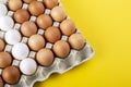 Nice big rural fresh eggs in cardboard egg box holder with colorful yellow background Royalty Free Stock Photo